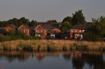 red brick houses on the pond at sunset