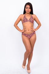 Young Asian woman wearing swimwear against white background