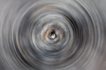 Blurred gradient radial motion black, gray, brown background. Mixed circular texture