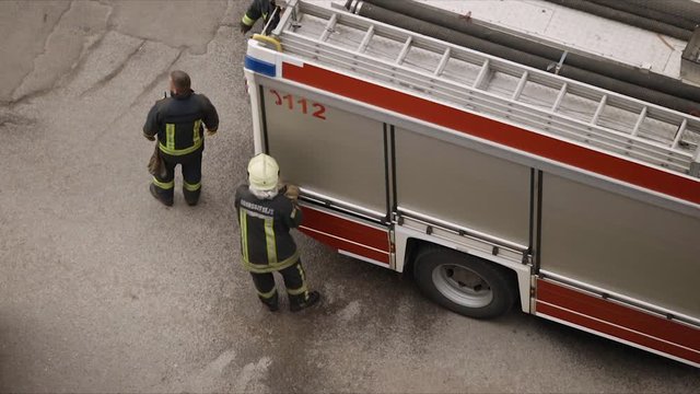 Firefighters stand near fire truck