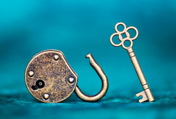 Success, solution, life coaching mentor concept. Key and unlocked padlock on blue background.