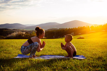 Mother and son practicing yoga in nature