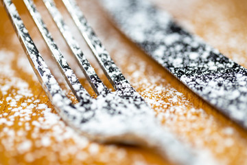 White sugar spray above a fork, close-up macro details.