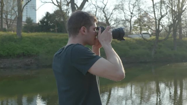 Photographer is doing pictures in park at sunset