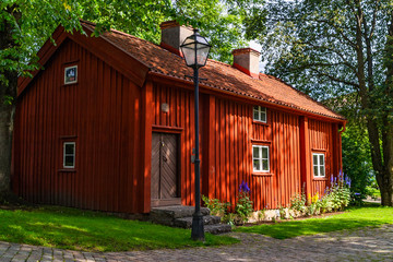 Fototapeta na wymiar Old red cottage in a park