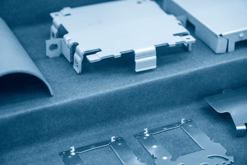 The sample of sheet metal plate in the light blue scene. The hi technology manufacturing process of automotive parts by progressive die.
