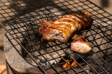 Roast pork neck on the stove with charcoal from wood.
