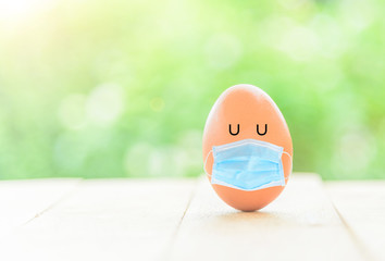 egg with hygienic mask on wood plate