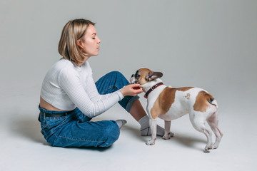 french bulldog and his mistress girl in a white sweater in the studio on a white background