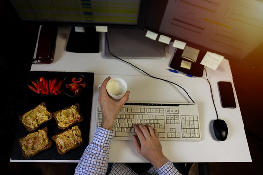 Busy Business Man Eating Healthy Avocado Toast Breakfast While Working On Computer