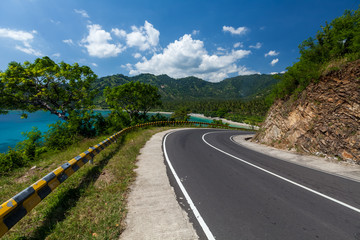 Scenic asphalt road along the coastline of the island of Lombok in Indonesia