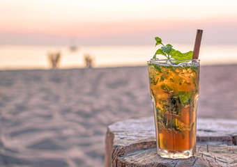 drink with blur beach and sunset in background