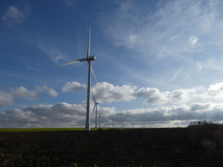 Row of six wind turbines in a field in France, Europe