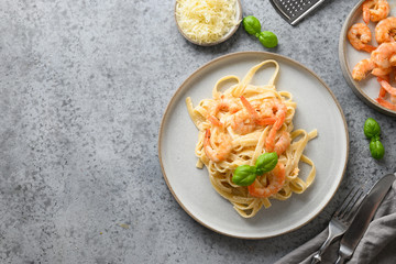 Italian pasta fettuccine with seafood, shrimps on gray table. View from above. Copy space.