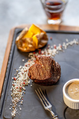 Beef steak with sauce and potato and shot of whisky