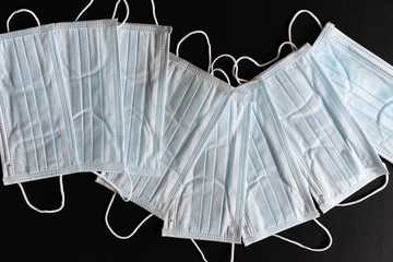 Protective masks on black background. Unused surgical masks on black background. Medical personal protective equipment