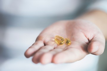image of yellow pills in hand.