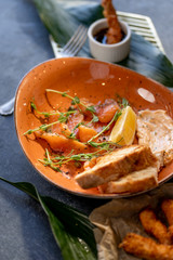 Sliced salmon with toast and dressing on stone background