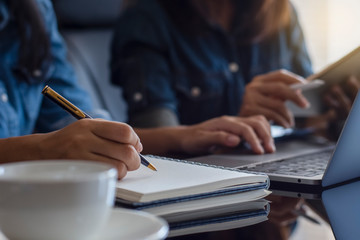 Two business woman or female student make online studying or remote working by using laptop computer and digital tablet at home or workplace. Digital technology or online education concept.