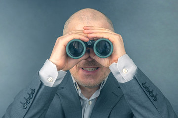 man in a business suit looks through binoculars. goals in a successful business.