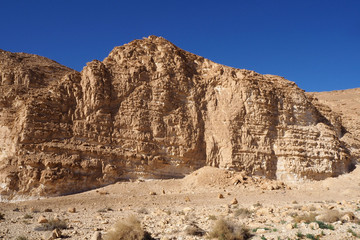 Fototapeta premium The high sandstone rock in the desert and the blue clean sky