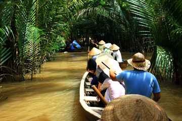 przewóz ludzi w łodziach wietnamską rzeką w otoczeniu palm