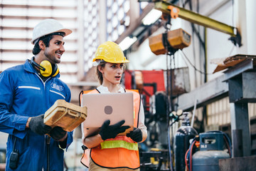 Male and female industrial worker or engineers in hard helmet discuss project while using laptop....