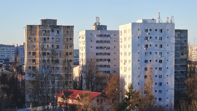 Time lapse of shadows on tall apartment buildings at sunrise, in Bucharest, Romania. Looping video.