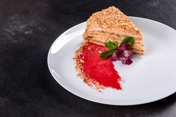 Fresh delicious cake napoleon with cream on a dark background