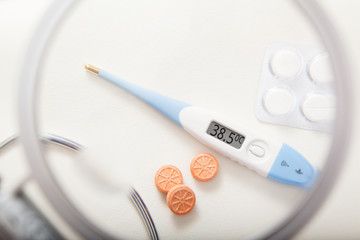Electronic thermometer with 38.5 degrees temperature and pills