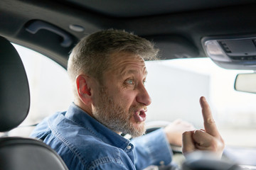 unfriendly aggressive car driver showing the middle finger