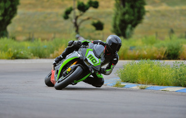 Motorcycle practice leaning into a fast corner on track