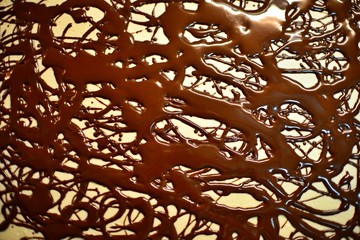 Chocolate lines on sweet cake. Abstract random chocolate painting.