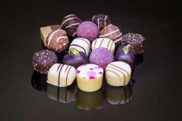 Chocolate candies and pralines with pink dots.