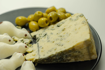 Full fat soft blue veined cheese with olives and snacks in the shape of mice