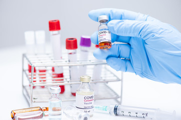 Doctor hand holding ampules and different medicine bottle on white background in  the...
