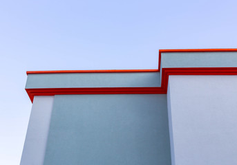Cornice of a multistory building on a background of cloudless sky