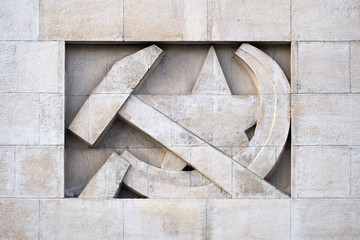 Stone bas-relief in the form of a symbol of the USSR. Sickle, hammer and star