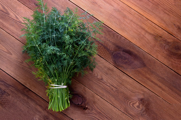 Bunch of fresh dill herb isolated on wooden background, top view
