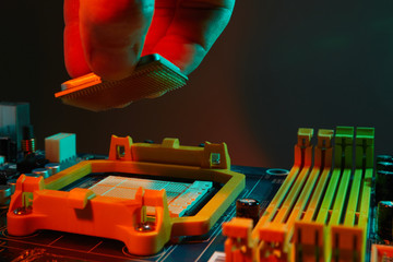 Engineer repairman holding chip CPU to insert into the socket of computer motherboard. Concept of...