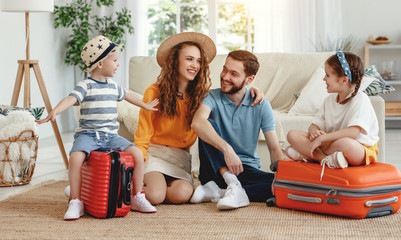 Cheerful family with suitcases on floor