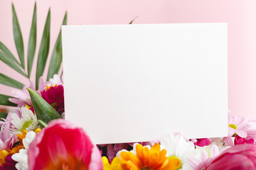 Flowers mock up congratulation. Congratulations card in bouquet of flowers on pink background....