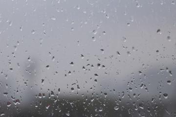Rain on the surface of the window Stop and flow into the rain. With cloudy backgrounds, natural patterns of isolated raindrops