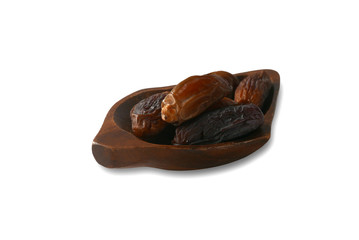 Dried dates fruit in a brown wooden bowl isolated on a white background.
