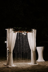 wedding arch decorated with lamps and flowers