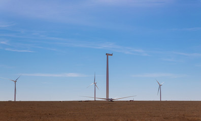 A panoramic view of the windmill installed in a field installation wind turbine with blue sky background