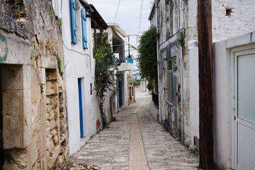 The old greek light street on the island of Crete. Along the walls grow local plants