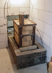 Sauna stove that is being built from fire resistant material in undeveloped interior laid out of foam blocks in country house under construction