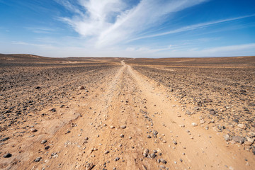 Fototapeta na wymiar Dirt road through endless Sahara desert, Morocco, Africa
