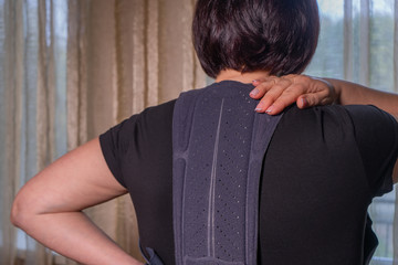 Middle-aged woman in a corset for posture,Trauma of back, spine pain
